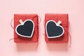 Valentine day composition: two red gift boxes with clothespin as heart with space for text on chalkboard on pastel pink background Royalty Free Stock Photo