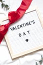 Valentine day concept flat lay on the white blanket with text. Holiday top view card with red roses. Royalty Free Stock Photo