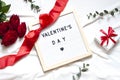Valentine day concept flat lay on the white blanket with text. Holiday top view card with red roses. Royalty Free Stock Photo