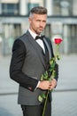 valentine day concept. grizzle black tuxedo man with valentine rose. flower gift for valentine day