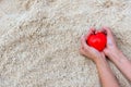 Valentine day, Hand woman holding red heart shape on the sand beach, Royalty Free Stock Photo