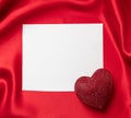 Valentine red color ruby heart on blank white card on red silk background Royalty Free Stock Photo