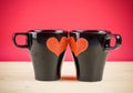 Valentine day series, cups of milk with decorative heart on wood table and red background