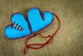 Hand stitched blue foam sheet toy hearts on jute Royalty Free Stock Photo