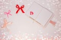 Valentine flatlay. Blank diary, pink heartshaped beads, hearts and ribbon on white background.Notebook mockup,cute style