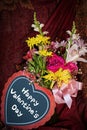 Valentine flowers and heart that says Happy Valentine`s Day against dark draped background Royalty Free Stock Photo