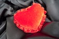 Valentine fluffy heart pillow over black satin Royalty Free Stock Photo