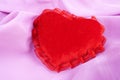 Valentine fluffy heart pillow over violet satin Royalty Free Stock Photo