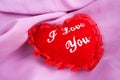 Valentine fluffy heart pillow over violet satin Royalty Free Stock Photo