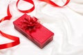 Valentine gift box. Red ribbon bow present with red roses on holiday Royalty Free Stock Photo