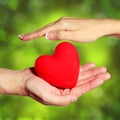 Valentine Heart in Female and Male Hands, over Green