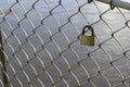Valentine heart padlock attached to wire mesh fence. Love padlocks hanging on a bridge Royalty Free Stock Photo