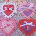 Valentine lace, doily, ribbon, and button hearts on fabric Royalty Free Stock Photo