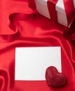 Valentine red color ruby heart on empty card on red silk fabric background Royalty Free Stock Photo