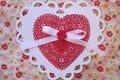 Valentine red and white lace, doily, ribbon, and button on yellow floral fabric heart Royalty Free Stock Photo