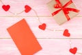 Gift Box with Ribbon Bow, Red Valentines Blank Card and Hearts on the Jute Rope Royalty Free Stock Photo