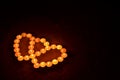 Symbolic heart shapes made from colorful candles burning in the darkness. Valentines day concept.