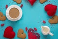 Valentine`s card and concept. Cup of black coffee with milk, red heart, sweets on blue. Top view.