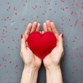 Valentine`s card concept with sweet red hearts in hand on gray background. Copy space. View from above. Royalty Free Stock Photo