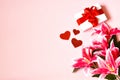 Valentine`s card. Gift box, lily flower and red hearts on a pink background Royalty Free Stock Photo