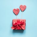 Valentine`s card. Lollipops candy as heart and gift on blue. Funny concept Royalty Free Stock Photo