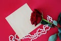 Valentine`s Day. ard on a red background a red rose with jewelry, a bottle of perfume and cosmetics. Royalty Free Stock Photo