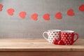 Valentine`s day background with coffee cups, heart shape chocolate and garland