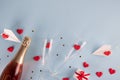 Valentine`s Day background. Gift box , alarm clock , red candy  hearts and paper plane, two champagne glasses on blue background Royalty Free Stock Photo