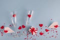 Valentine`s Day background. Gift box , alarm clock , red candy  hearts and paper plane, two champagne glasses on blue background Royalty Free Stock Photo