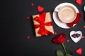 Valentine's Day background. Gift, coffee roses, candles, hearts on black background. Valentines day concept. Flat