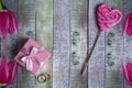 Valentine`s day background with a gift in a pink box, wedding rings and a sweet lollipop in the form of a heart. Vintage style Royalty Free Stock Photo