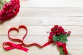 Valentine`s day background image with red ribbon beautiful heart shapes and red roses. Resting on a wooden table Royalty Free Stock Photo