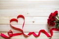 Valentine`s day background image with red ribbon beautiful heart shapes and red roses. Resting on a wooden table Royalty Free Stock Photo