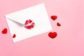 Valentine`s day background. Envelope with red lipstick kiss and hearts on pink.