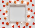 Valentine`s Day background. A mockup of an empty wooden photo frame, a glowing garland, physalis flowers and figurines Royalty Free Stock Photo