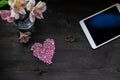 Valentine`s day background - pink heart, flowers, tablet and wedding rings on a dark background Royalty Free Stock Photo