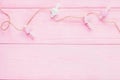 Valentine`s day background. Pink and white hearts with clothespins in a clothes line on a pink wooden background. Top view, copy Royalty Free Stock Photo