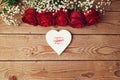 Valentine's day background with red roses and heart shape on wooden table. View from above Royalty Free Stock Photo