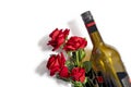 Valentine`s Day background. Wine bottle with bouquet of red plastic roses on isolated white background. Top view, copy space Royalty Free Stock Photo