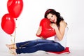 Valentine's day beautiful young woman wearing red dress and holding red balloons