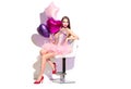 Valentine`s Day. Beauty fashion model party girl with heart shaped air balloons having fun, sitting on chair isolated on white