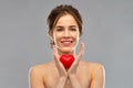 Beautiful smiling woman holding red heart Royalty Free Stock Photo