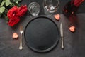 Valentine`s day or birthday dinner. Elegance table setting with red rose on black linen tablecloth Royalty Free Stock Photo