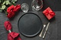 Valentine`s day or birthday dinner. Elegance table setting with red rose on black linen tablecloth Royalty Free Stock Photo