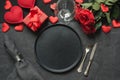 Valentine`s day or birthday dinner. Romantic table setting with red rose on black linen tablecloth Royalty Free Stock Photo