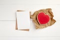 Valentine`s day blank greeting card mockup with paper envelope and red heart on white wooden table Royalty Free Stock Photo