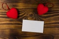 Valentine`s day blank greeting card and two red hearts on wooden background Royalty Free Stock Photo