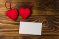 Valentine`s day blank greeting card and two red hearts on wooden background Royalty Free Stock Photo