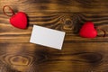 Valentine`s day blank greeting card and two red hearts on wooden background Royalty Free Stock Photo