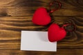 Valentine`s day blank greeting card and two red hearts on wooden background Royalty Free Stock Photo